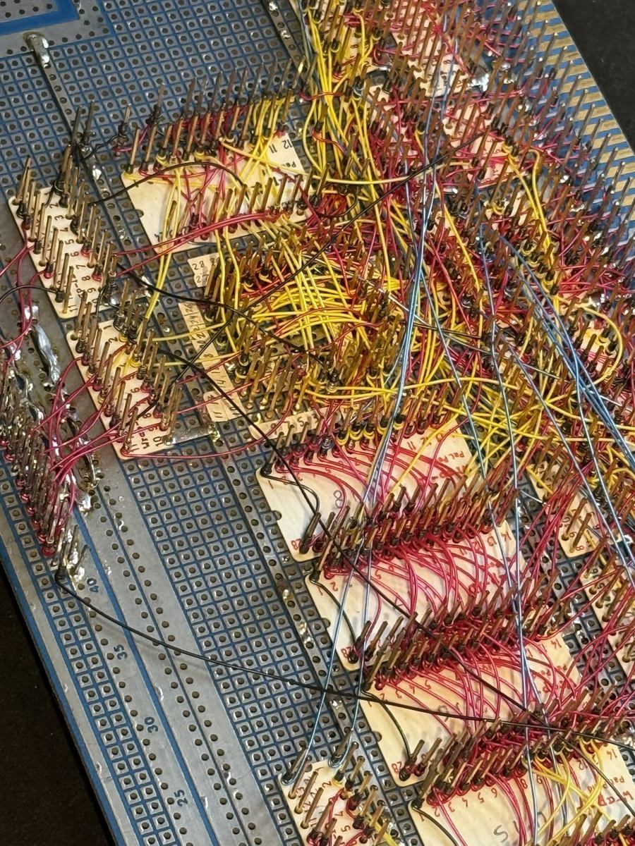 Wire-wrap side of the NS32032 audio computer: dense hand-routed red, yellow, and blue wire-wrap wiring across a field of socket pins.